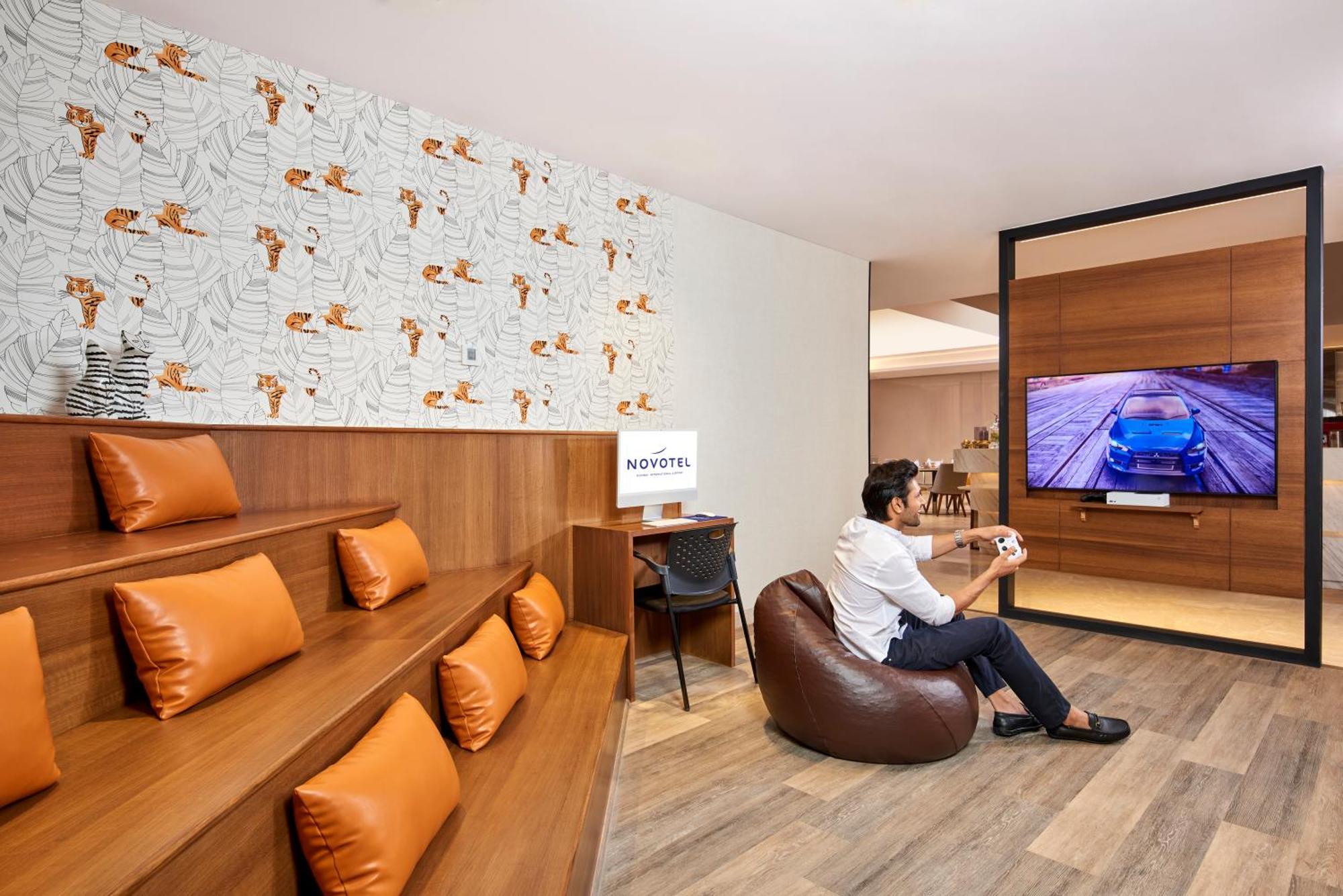Novotel Mumbai International Airport Экстерьер фото A man playing a video game at the lounge